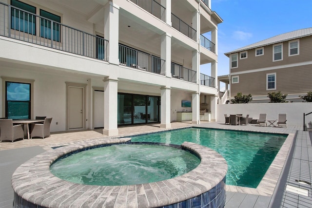 view of pool with an in ground hot tub and a patio