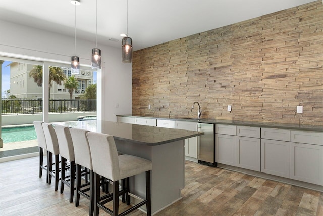 kitchen featuring a kitchen island, a healthy amount of sunlight, light wood-type flooring, and pendant lighting