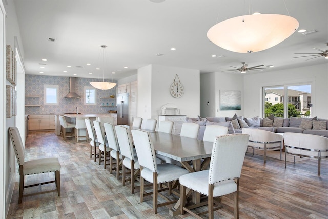 dining room featuring a wealth of natural light, light hardwood / wood-style flooring, ceiling fan, and sink