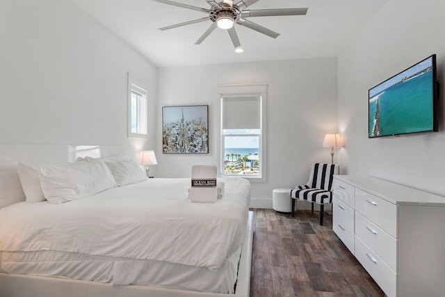 bedroom featuring dark hardwood / wood-style flooring, ceiling fan, and multiple windows