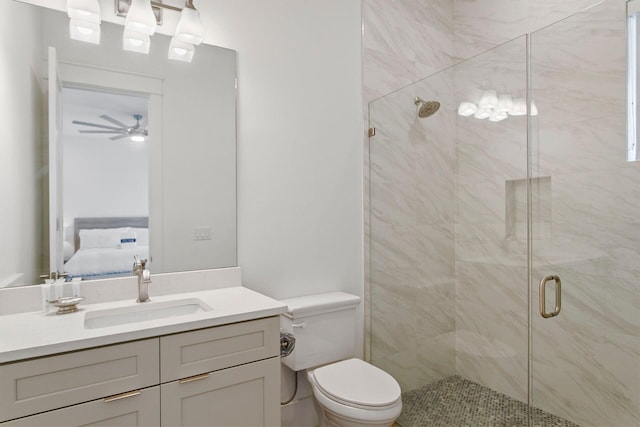 bathroom with a shower with door, oversized vanity, ceiling fan, and toilet