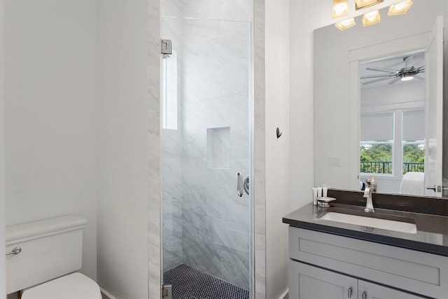 bathroom featuring walk in shower, ceiling fan, vanity, and toilet