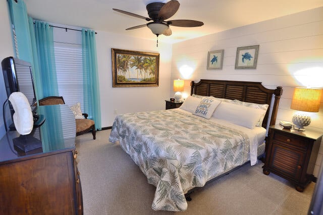 bedroom with ceiling fan and dark carpet