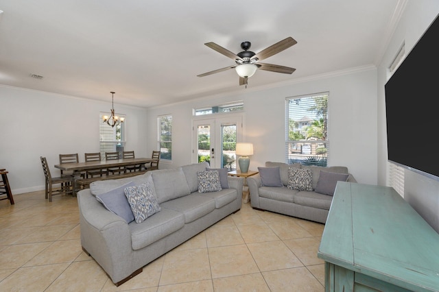 living room with ceiling fan with notable chandelier, french doors, crown molding, and light tile flooring