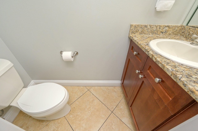 bathroom with toilet, tile floors, and vanity