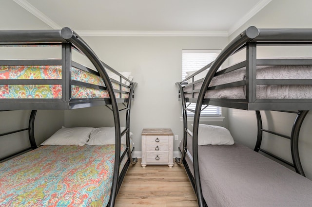 bedroom featuring ornamental molding and light wood-type flooring