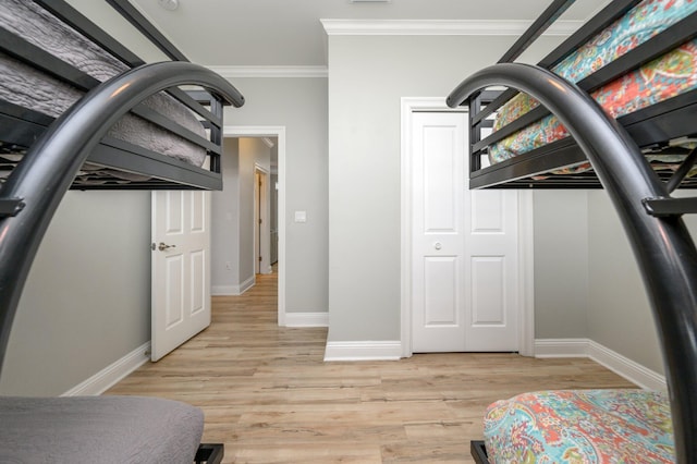 bedroom with ornamental molding, a closet, and light wood-type flooring