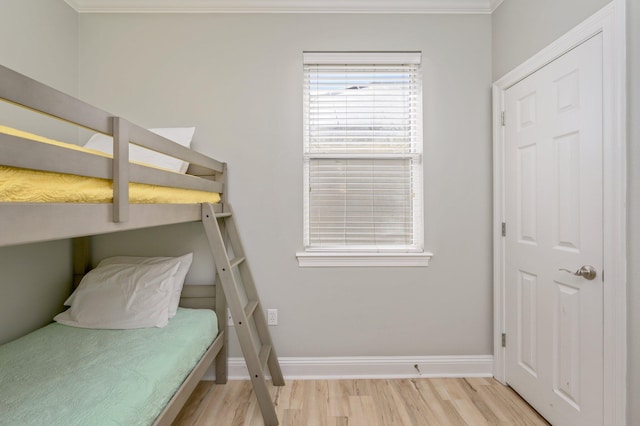 bedroom with crown molding and light hardwood / wood-style floors