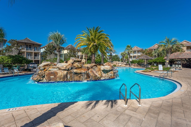 view of swimming pool featuring pool water feature and a patio area