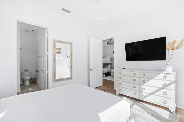 bedroom featuring ceiling fan, hardwood / wood-style flooring, and ensuite bathroom