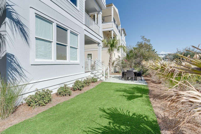 view of yard featuring a patio and a balcony