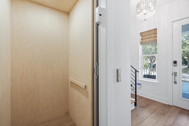 interior space with hardwood / wood-style floors, a chandelier, and elevator