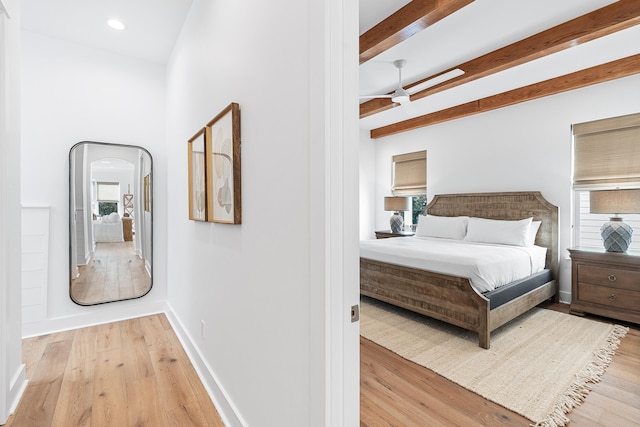 bedroom featuring beamed ceiling and light hardwood / wood-style flooring