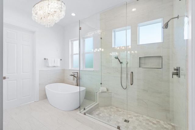 bathroom featuring tile walls, tile flooring, separate shower and tub, and a notable chandelier