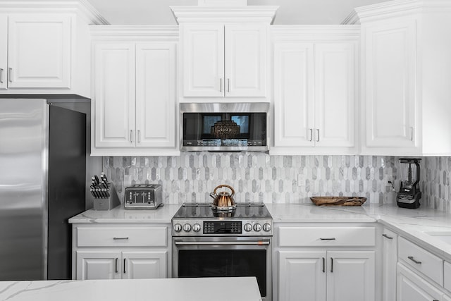 kitchen featuring appliances with stainless steel finishes, white cabinetry, and light stone countertops