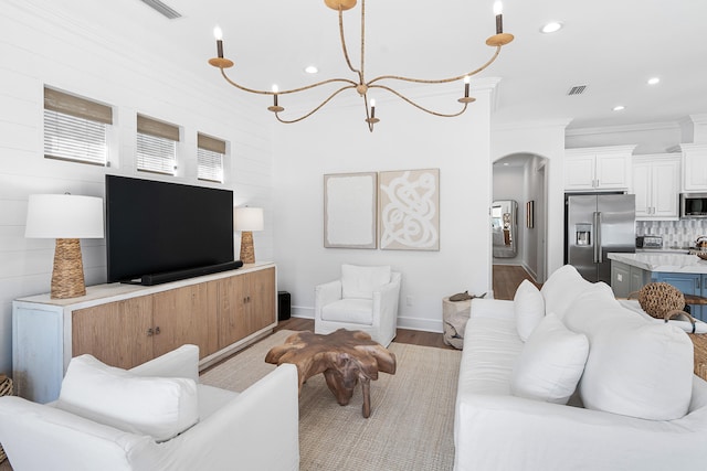 living room with ornamental molding and light hardwood / wood-style floors