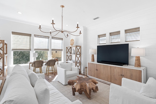 living room with light hardwood / wood-style flooring, a notable chandelier, and crown molding