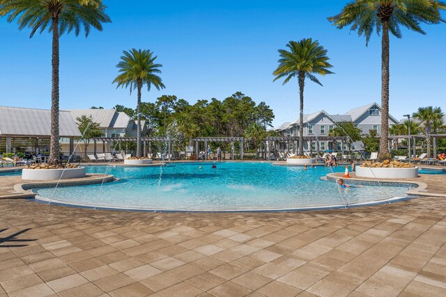 view of swimming pool with a patio, a pergola, and pool water feature