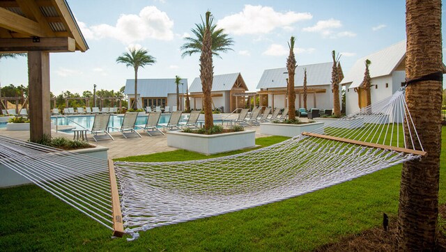 view of home's community featuring a swimming pool, a lawn, and a patio