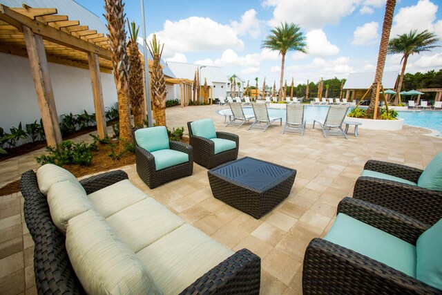 view of patio / terrace with a community pool, outdoor lounge area, and a pergola