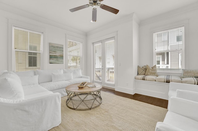 living room featuring wood-type flooring, ceiling fan, and crown molding