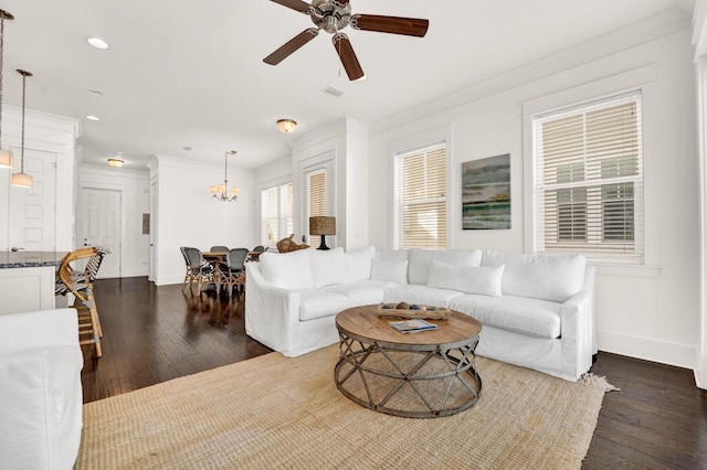 living room with crown molding, dark hardwood / wood-style flooring, and ceiling fan with notable chandelier