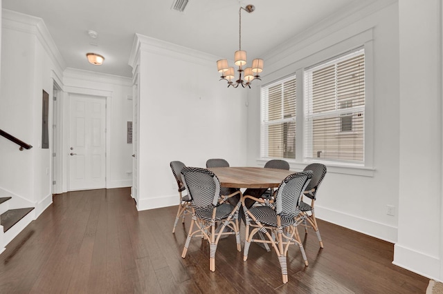 dining area with crown molding, dark hardwood / wood-style floors, and an inviting chandelier