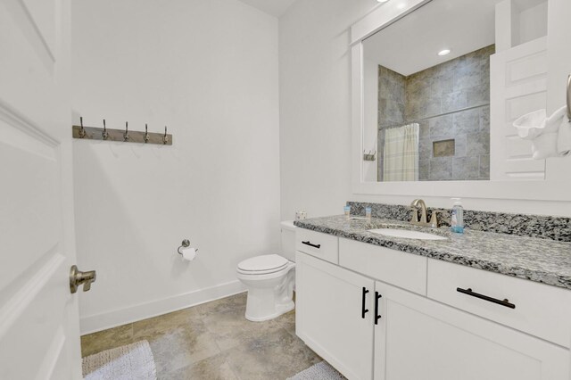 bathroom with a shower, vanity, and toilet