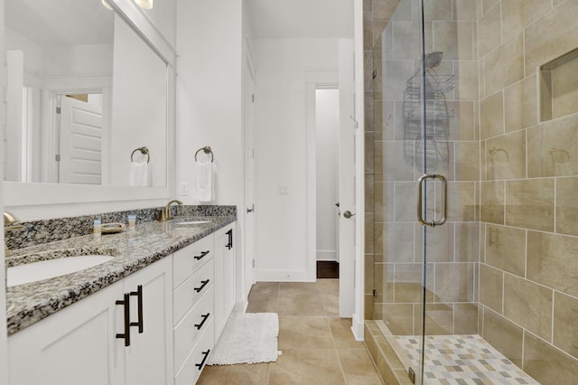 bathroom featuring tile patterned floors, a shower with shower door, and vanity