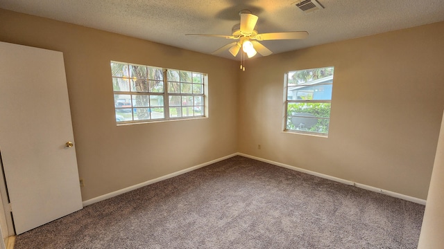 carpeted spare room featuring ceiling fan and a textured ceiling