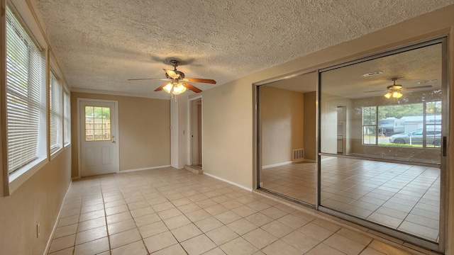 tiled spare room with ceiling fan