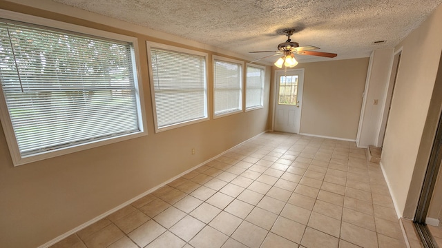 unfurnished sunroom featuring ceiling fan