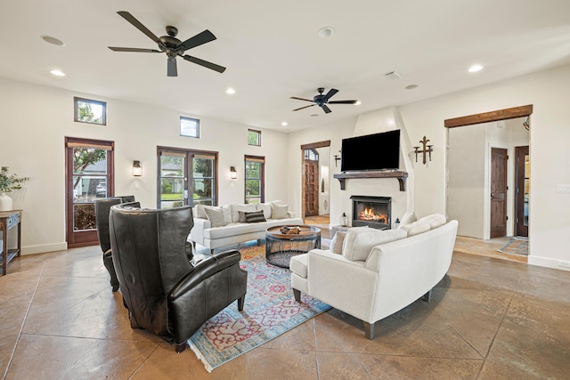 tiled living room featuring ceiling fan, french doors, and a fireplace