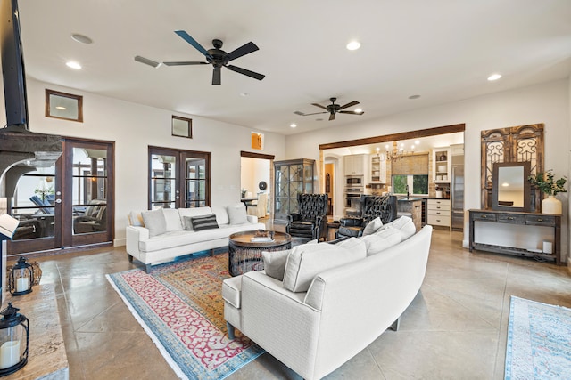 tiled living room with french doors, ceiling fan, and sink