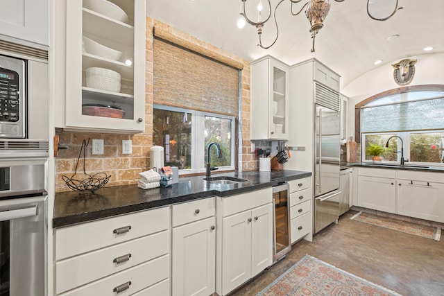 kitchen featuring sink, plenty of natural light, backsplash, and built in appliances