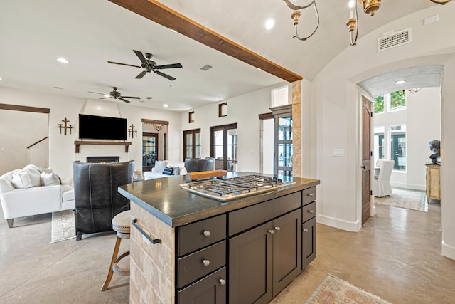 kitchen featuring a center island, french doors, stainless steel gas stovetop, a breakfast bar area, and ceiling fan