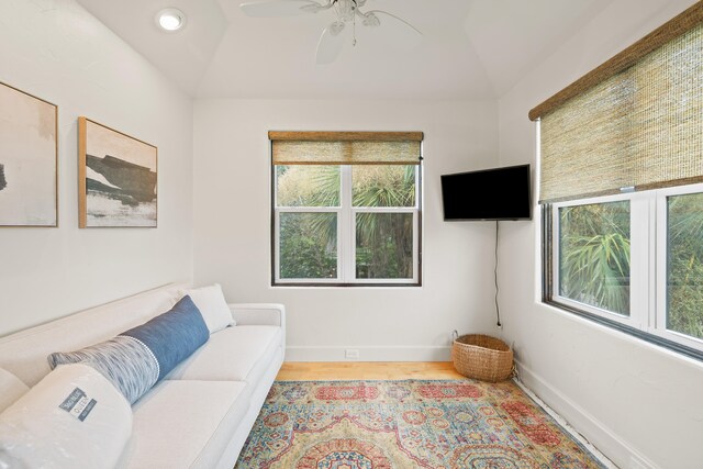 living room with lofted ceiling, ceiling fan, and light hardwood / wood-style floors