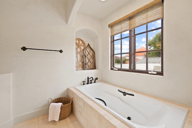 bathroom featuring tile flooring and tiled bath