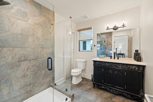 bathroom with tile flooring, a shower with door, vanity, and toilet