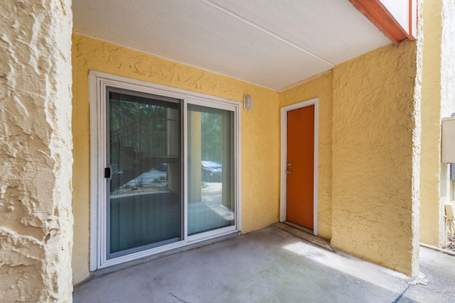 view of exterior entry with a patio area