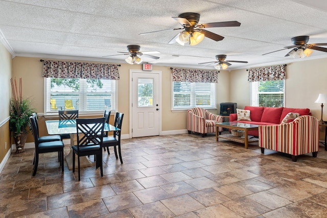 tiled dining space with a healthy amount of sunlight, ceiling fan, and crown molding