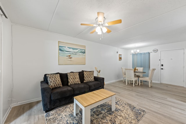 living room featuring wood-type flooring, a textured ceiling, and ceiling fan with notable chandelier