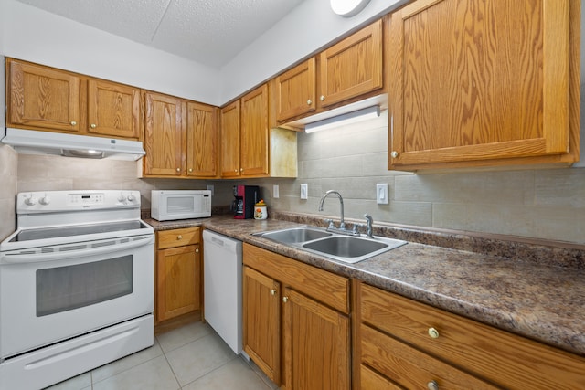 kitchen with white appliances, tasteful backsplash, sink, and light tile floors