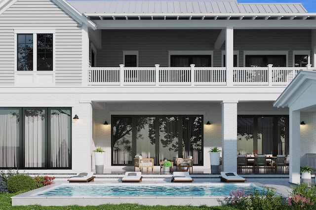 rear view of house with a balcony and a patio