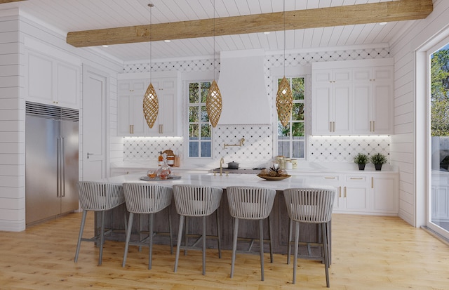 kitchen featuring light hardwood / wood-style floors, white cabinetry, hanging light fixtures, beam ceiling, and stainless steel built in fridge