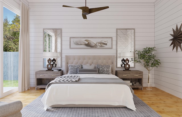 bedroom with multiple windows, light wood-type flooring, and access to outside