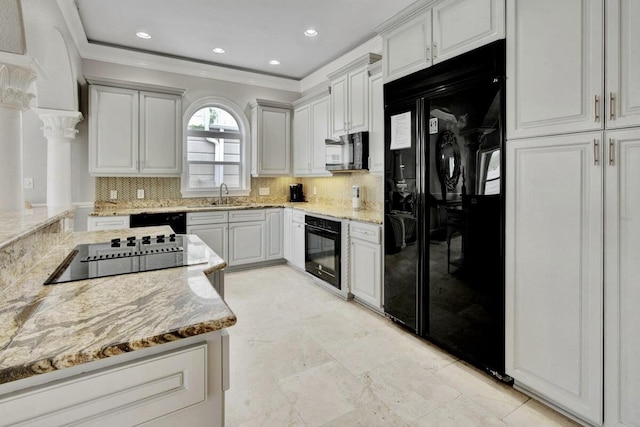 kitchen featuring sink, light stone counters, and black appliances