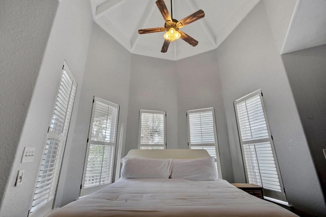 bedroom with ceiling fan, beam ceiling, and high vaulted ceiling