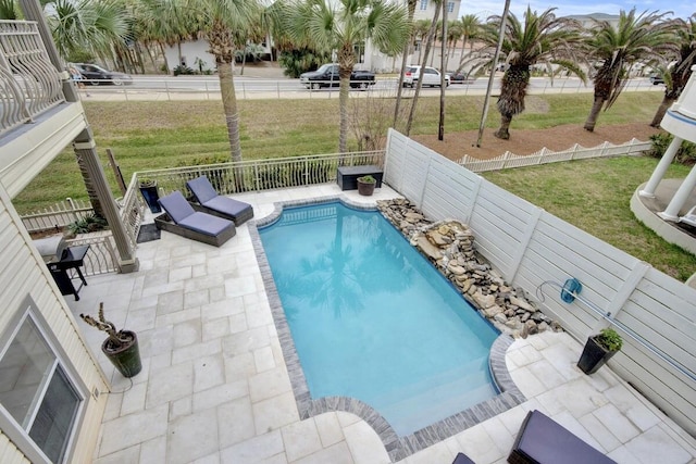 view of swimming pool featuring a yard and a patio