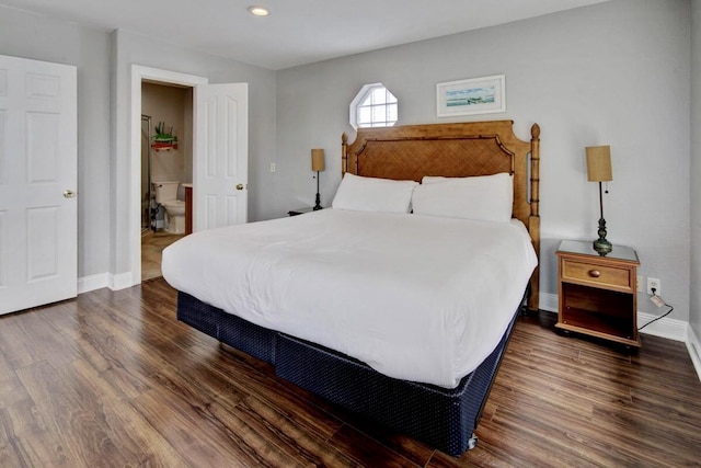 bedroom featuring dark wood-type flooring and ensuite bath